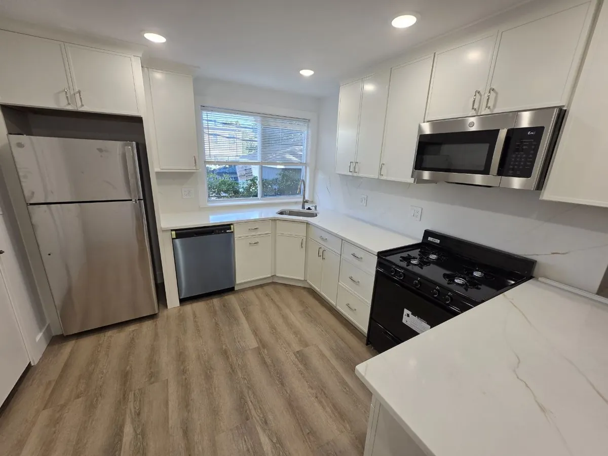 Renovated Boston apartment kitchen with new sink, dishwasher and gas range