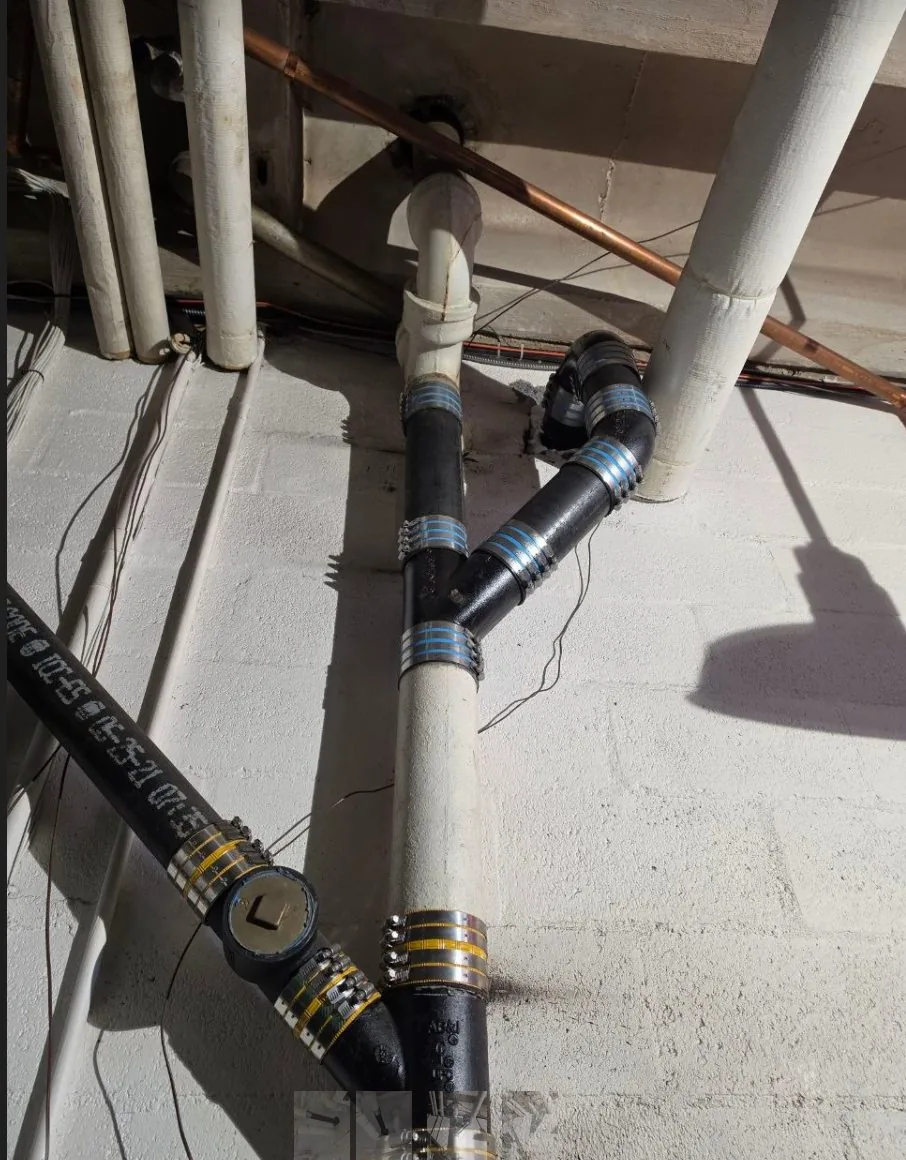 New cast-iron sewer pipe joined with shielded no-hub couplings after repair