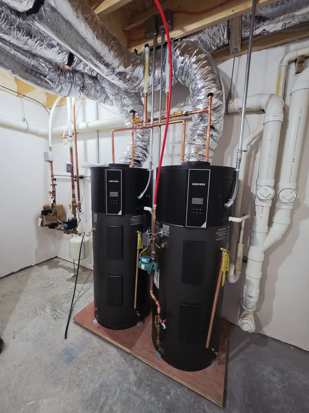 Copper piping and condensate drain on a pair of heat pump water heaters installed by IS Plumbing