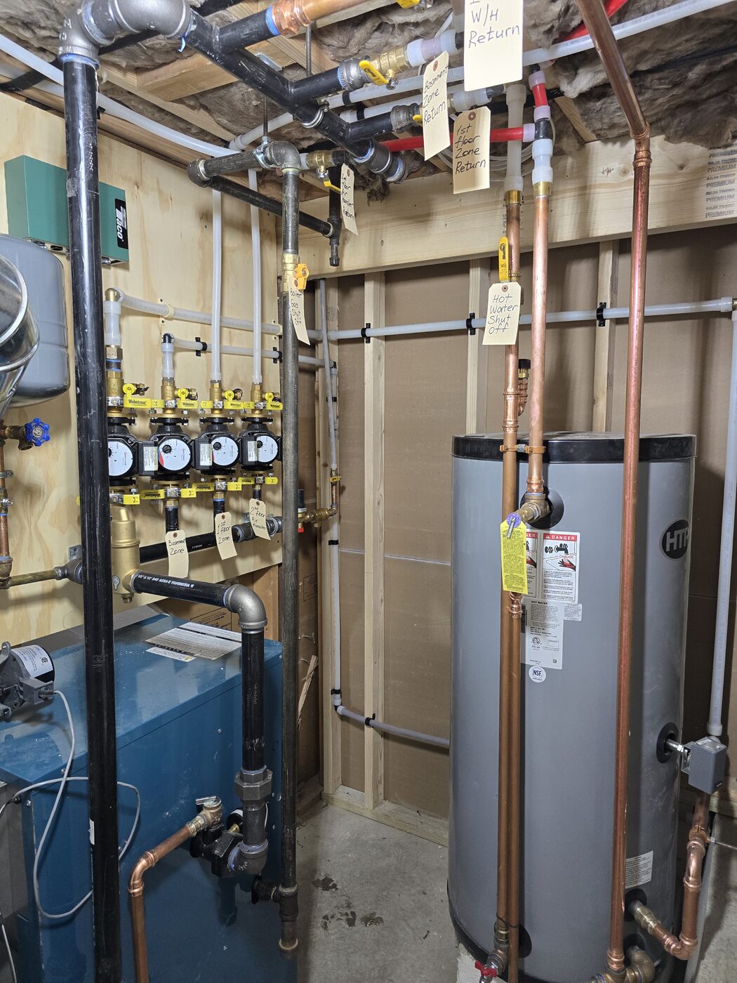 Basement mechanical room by IS Plumbing with labeled shutoff valves on every zone and appliance