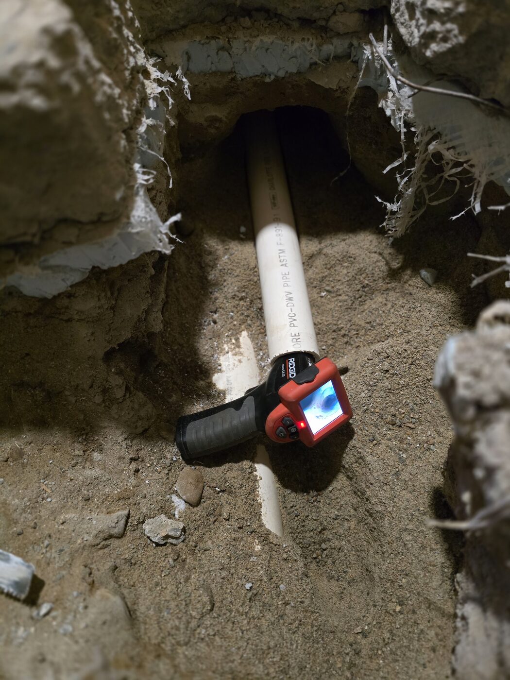 New drain pipe run through an opening cut under a foundation wall