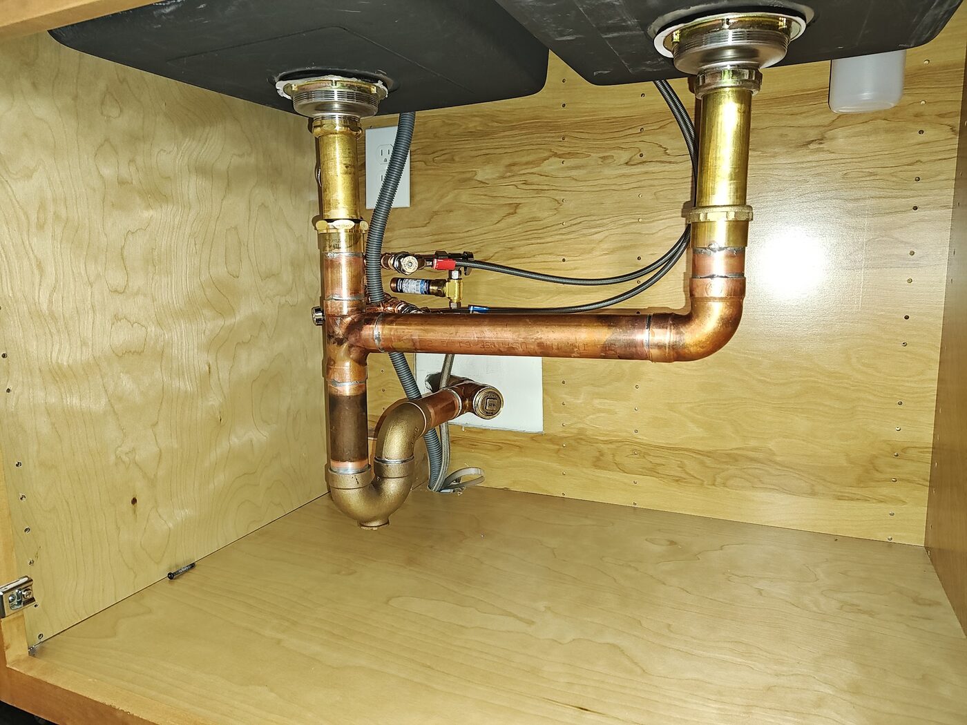 Copper drain and P-trap assembly rebuilt under a kitchen sink