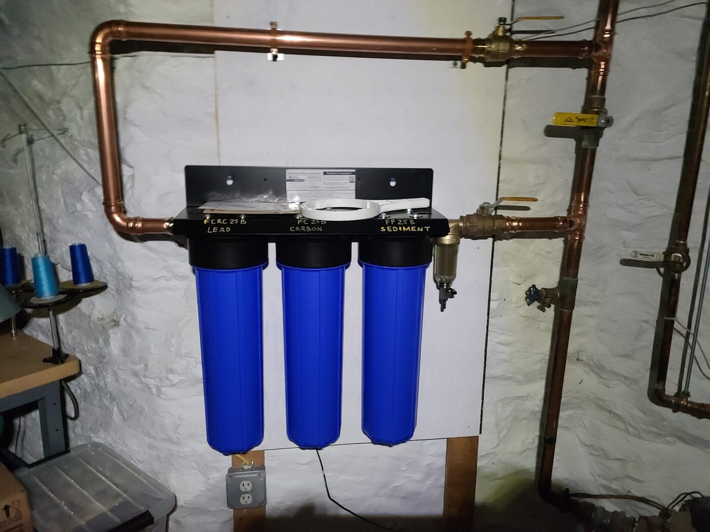 Three-stage whole-house water filter installed on the main line with copper piping and bypass valves