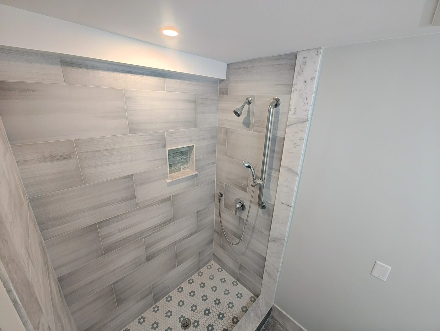 Tiled walk-in glass shower with marble-look porcelain