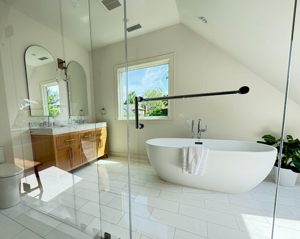 Master bathroom remodel with a soaking tub, glass shower and double vanity with arched mirrors